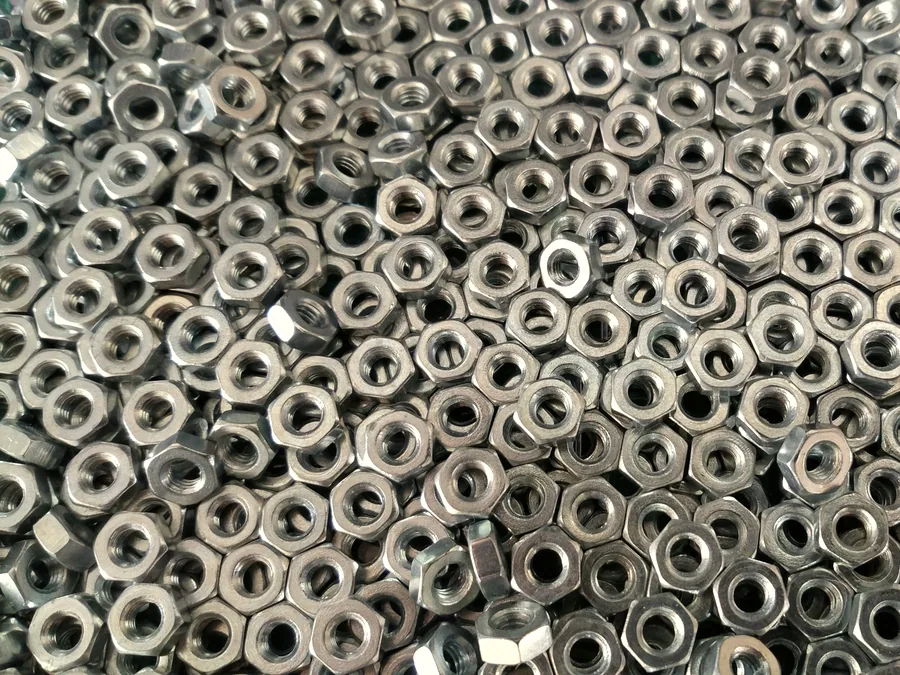 Field of steel hex nuts seen from above