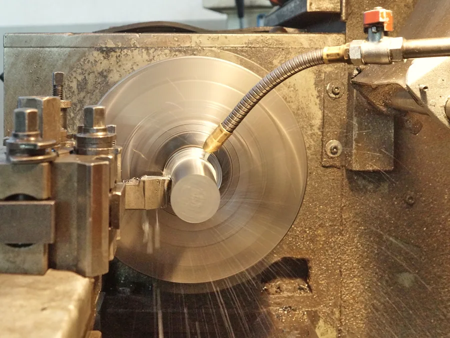 Machined component turning under coolant in a workshop