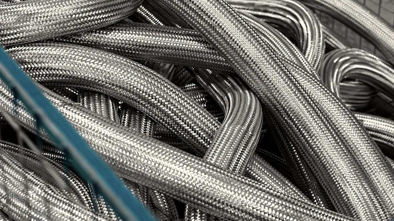 Coiled braided hydraulic hose stacked in a workshop bin