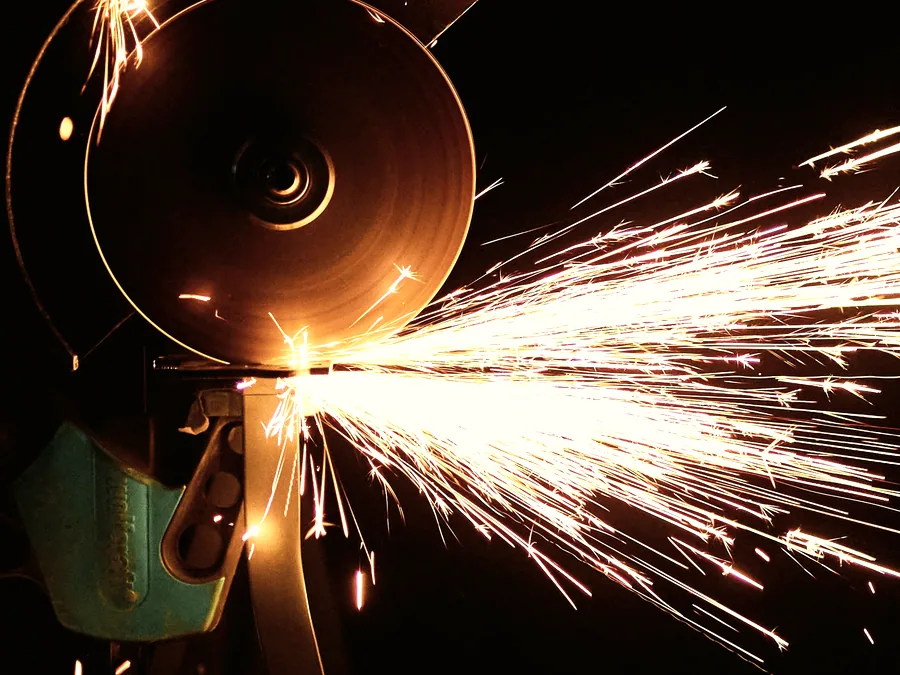Abrasive cutting disc throwing sparks as it cuts steel