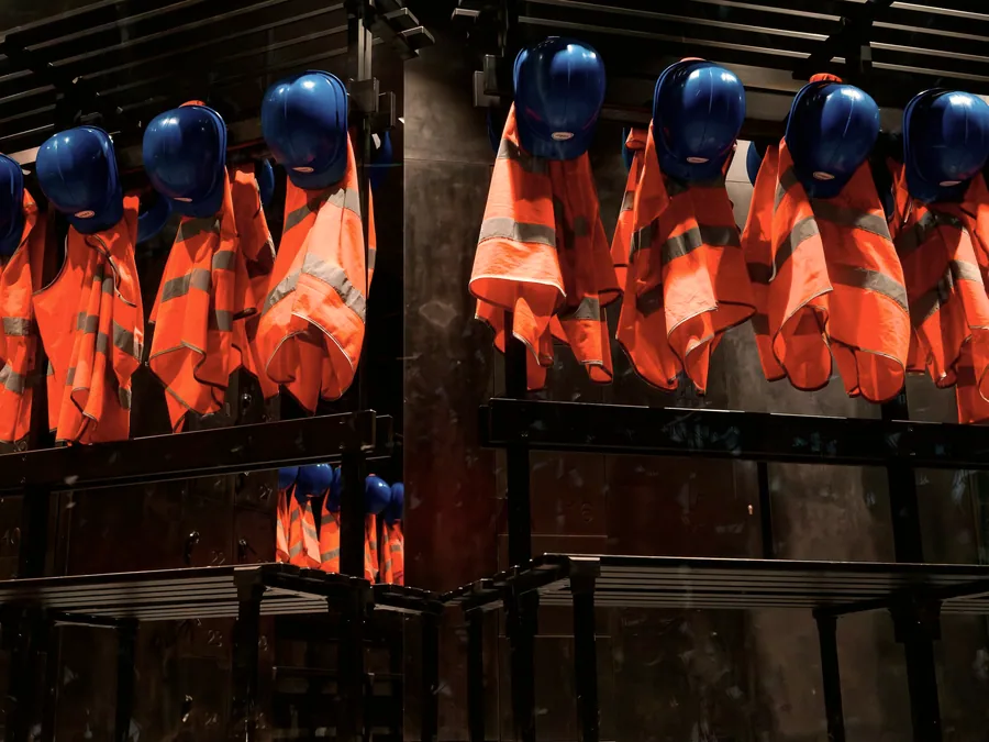 High-visibility vests and safety helmets stored ready for issue