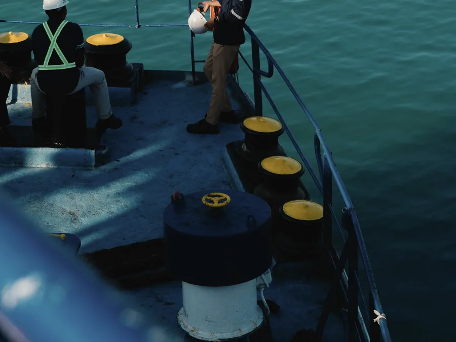 Crew in protective equipment working on deck alongside